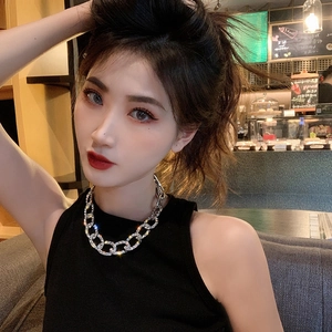 Détail du collier chaîne cubaine argentée orné de strass porté par un mannequin