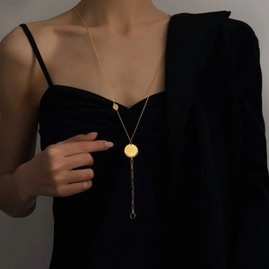 Minimalist golden Y-shaped lariat necklace with double circle pendants on a female model