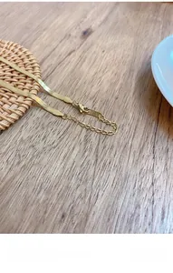 Macro detail of gold snake chain necklace with K18 engraving and lobster clasp