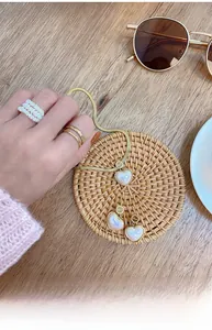 Flat lay of gold heart necklace set with matching earrings and pearl rings on a rustic mat