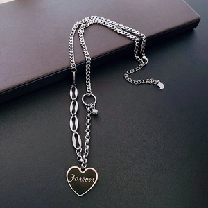 Detailed close-up of a silver heart pendant engraved with Forever on an asymmetric chain