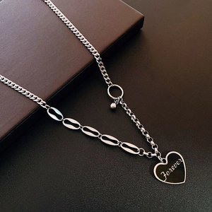 Detailed macro view of silver heart pendant with Forever engraving on a steel chain