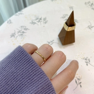 Gros plan d'une bague minimaliste en or avec un cristal étincelant au doigt