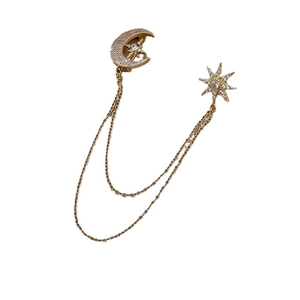 Elegant gold celestial brooch featuring sparkling moon and star charms with delicate double chains