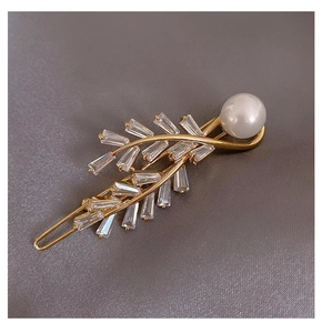 Detail of gold leaf hair clip with cubic zirconia stones and a white pearl accent