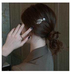 Detail of silver leaf hair clip with zircon rhinestones and pearl on model's hair