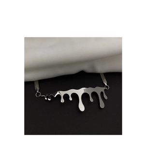Detailed close-up of a silver fluid drip pendant on a sleek flat snake chain necklace