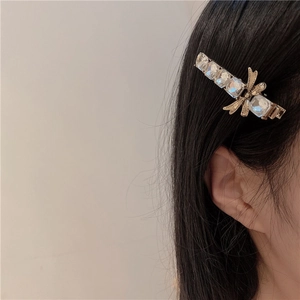 Dettaglio del fermaglio per capelli vintage con fiocco e cristalli indossato di lato