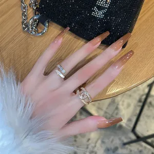 Close-up of luxury gold rings with micro-set diamonds on manicured hand and handbag