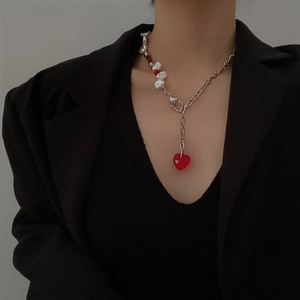 Close-up of heart-shaped red crystal pendant on irregular baroque pearl chain necklace