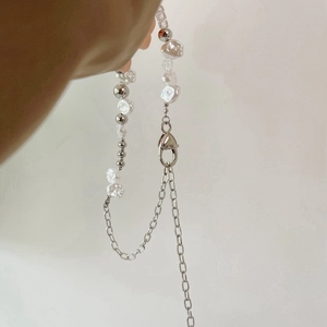 Baroque pearl necklace with heart pendant and silver chain held in hand closeup