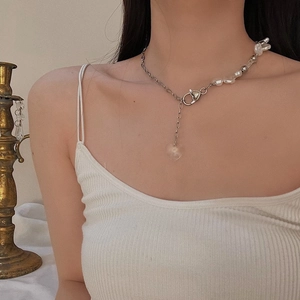 Detail of heart charm pendant and baroque pearls on asymmetric metal necklace