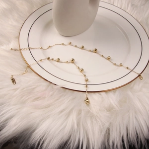 Minimalist 18K gold stainless steel anklet with beads on an elegant ceramic plate
