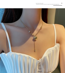 Dettaglio della collana con pendente a cuore dorato e stella su catena a strati