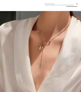 Collana a Y dorata con ciondolo a cuore e stella su un elegante tessuto di seta