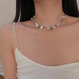 Baroque pearl necklace with silver metal beads worn by a model on white rib top