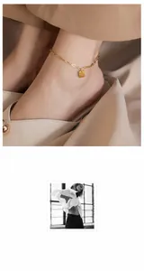 Detail der goldenen Fußkette mit quadratischem Anhänger, Good Luck Gravur und feiner Kettenglieder