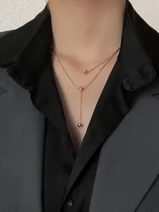 Double-layered gold titanium necklace with minimalist round beads and Y-shaped pendant