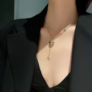 Elegante collana dorata con pendente a cuore e stella con design a Y indossata da modella