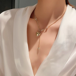 Elegante collana a Y dorata con ciondolo a cuore e stella indossata da una modella