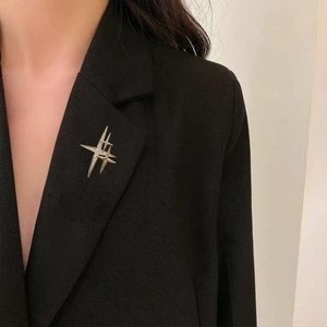 Dettaglio di una spilla a forma di stella d'argento con strass su una giacca nera elegante
