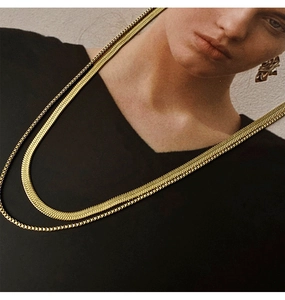 Detailed close-up of double-layered gold snake bone and bead chains for women