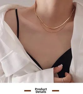 Close-up of double-layered gold snake chain necklace worn on neck with white shirt