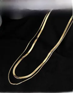 Detail of double-layer gold necklace featuring sleek snake chain and delicate O-link chain