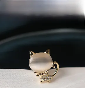 Gros plan sur la broche chat doré avec pierre d'opale et détails en cristal