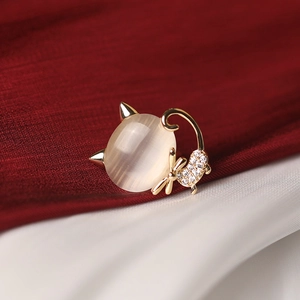 Exquise broche chat dorée avec pierre opale beige et détails de cristaux scintillants