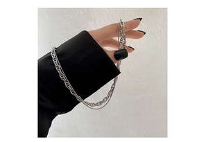 Detail of layered silver chain bracelet with black rectangular pendant on a black sleeve