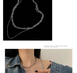 Close-up of layered silver titanium steel chain necklace on model with denim jacket