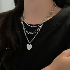 Macro detail of multi-layered silver titanium steel necklace with heart pendant