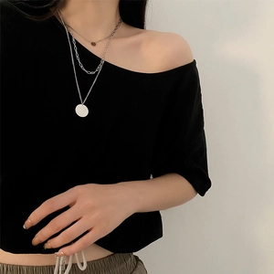 Three-layer layered necklace featuring paperclip chain and round pendants on black top