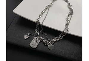 Macro shot of silver tiger tag and lucky pendant on double layered titanium necklace