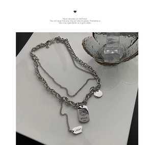 Macro detail of silver-tone double layer titanium steel chain with brave tiger pendant