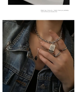 Macro detail of silver titanium steel tiger pendant and layered hip-hop chain necklaces