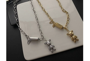 Détails des pendentifs ours en or et argent avec gravures Lucky et Peace sur les médaillons