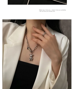 Collier ours argenté et bague chaîne assortie portés par un mannequin en blazer