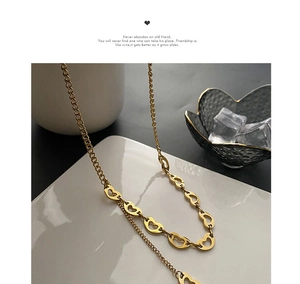Detailed close-up of golden heart-shaped linked chain necklace on display background