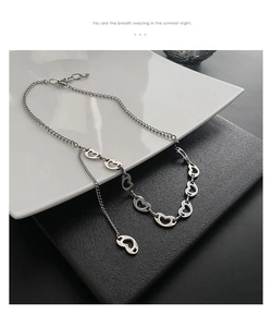 Close-up of titanium steel tassel necklace with hollow heart links in silver finish