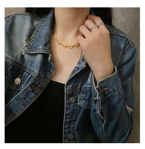 Macro shot of gold heart-shaped link necklace worn on model for casual jewelry style