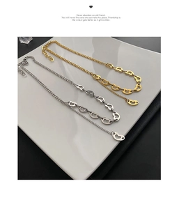Detail of gold and silver heart-shaped pendant necklaces on a white tray display