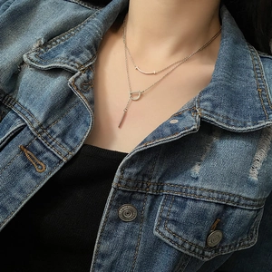Collier double couche argenté avec barre sourire et pendentif D sur un modèle