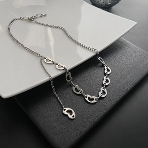 Minimalist silver heart link chain necklace with lobster clasp on sleek black leather background