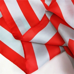 Detail view of red and white striped satin scarf showing fabric texture and edge stitching