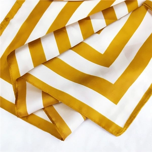 Detailed view of yellow and white striped square silk scarf with satin finish texture