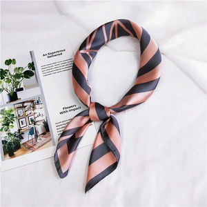 Detail of pink and grey striped silk scarf with elegant geometric patterns on fabric