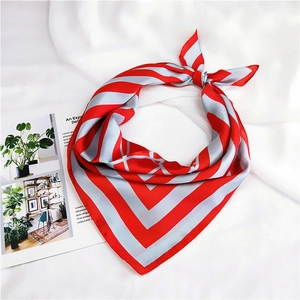 Close-up of a striped silk scarf tied in a knot on a white fabric background