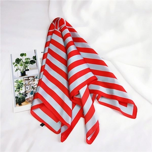 Detail of red and gray striped silk scarf with elegant sheen on white fabric